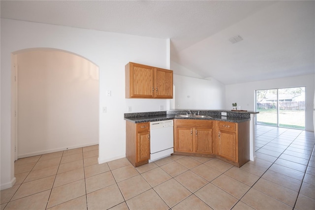 kitchen featuring lofted ceiling, sink, dark stone countertops, white dishwasher, and kitchen peninsula