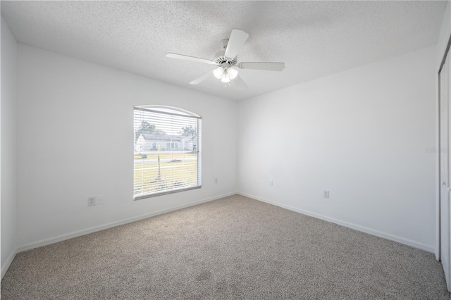 unfurnished room featuring ceiling fan, carpet, and a textured ceiling