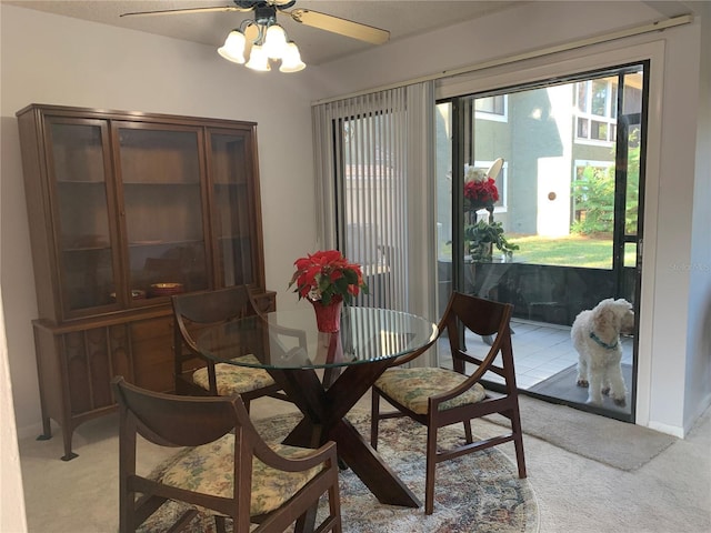 dining area featuring ceiling fan and light carpet