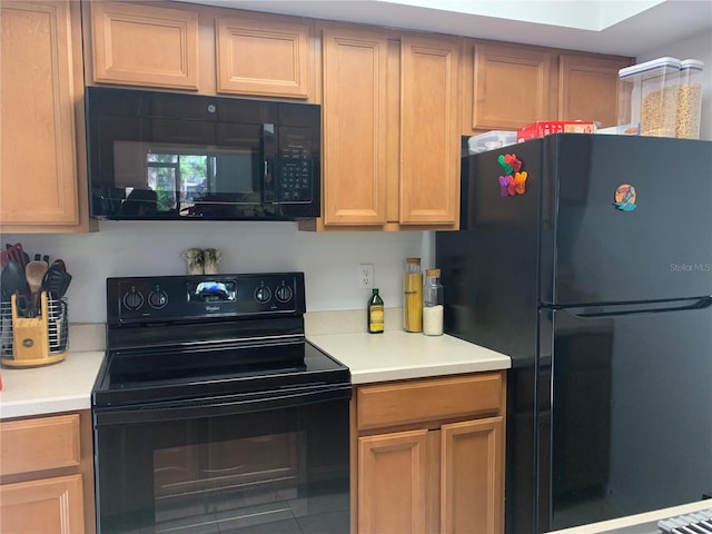 kitchen with light countertops, tile patterned flooring, and black appliances