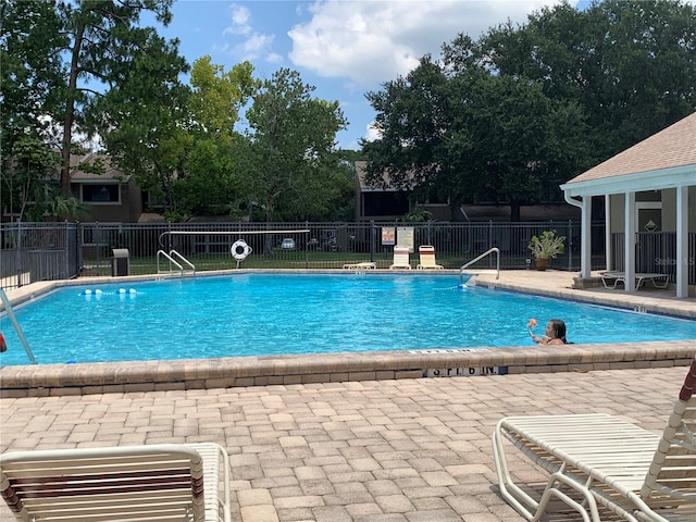 community pool featuring a patio area and fence