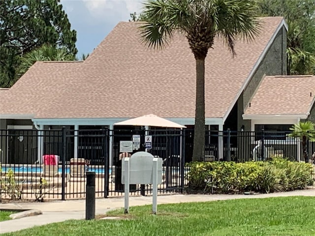 rear view of property with fence and roof with shingles