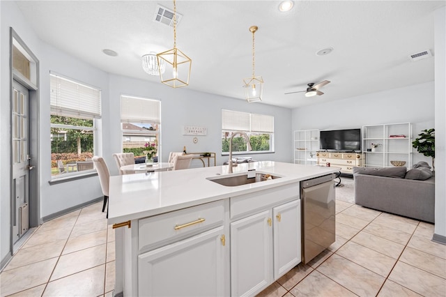 kitchen featuring dishwasher, an island with sink, sink, white cabinetry, and hanging light fixtures