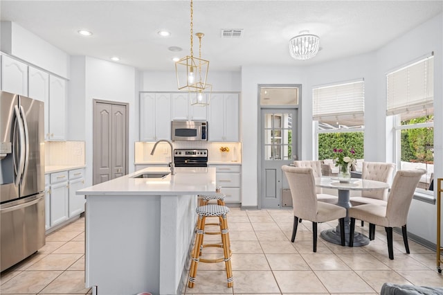 kitchen with sink, decorative light fixtures, stainless steel appliances, and backsplash