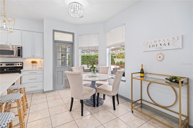 tiled dining room featuring a notable chandelier