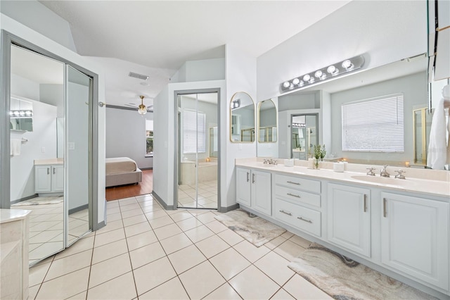 bathroom with a relaxing tiled tub, ceiling fan, tile patterned floors, and vanity