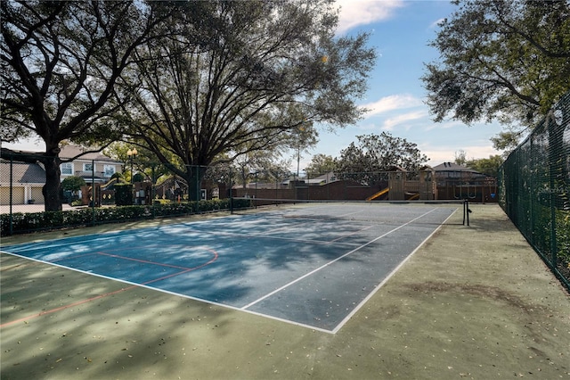 view of tennis court with a playground