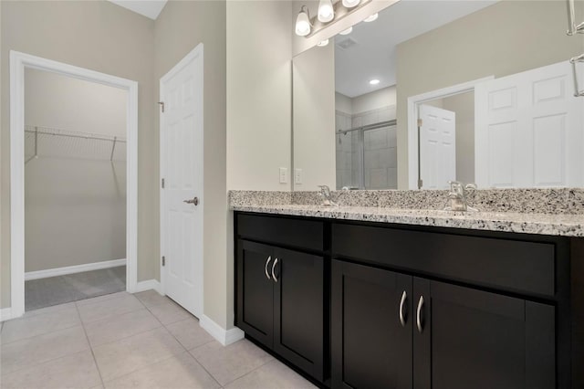 bathroom with tile patterned flooring, vanity, and an enclosed shower