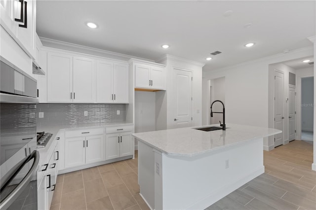 kitchen with white cabinetry, a kitchen island with sink, and sink