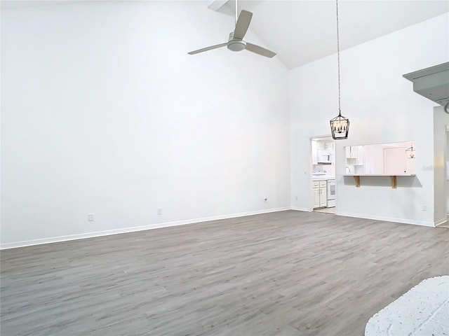 unfurnished living room with ceiling fan, hardwood / wood-style floors, and high vaulted ceiling