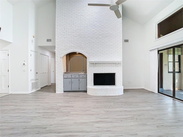 unfurnished living room featuring light hardwood / wood-style flooring, high vaulted ceiling, and ceiling fan