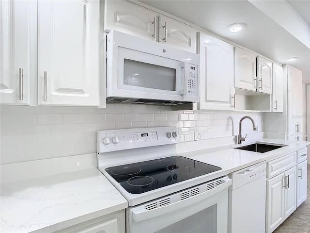 kitchen with white cabinets, decorative backsplash, white appliances, and sink