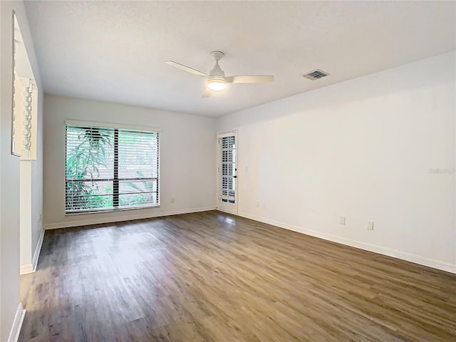 spare room with dark hardwood / wood-style flooring and ceiling fan