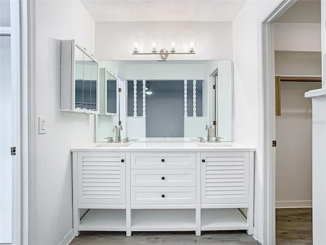 bathroom with vanity, wood-type flooring, and a textured ceiling