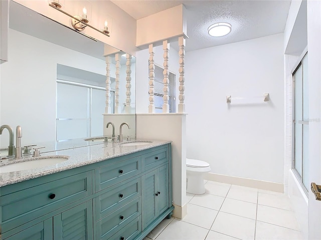 full bathroom featuring vanity, a textured ceiling, enclosed tub / shower combo, tile patterned flooring, and toilet