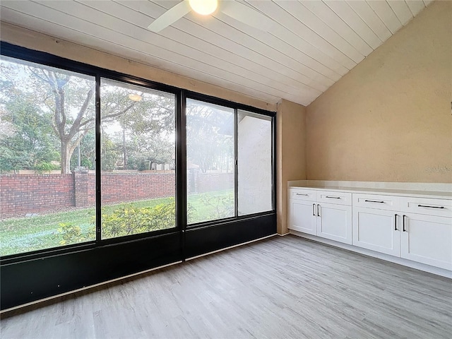 unfurnished sunroom with ceiling fan, lofted ceiling, and wooden ceiling