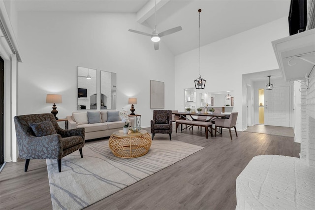 living room with wood finished floors, baseboards, high vaulted ceiling, ceiling fan, and beamed ceiling