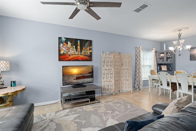 tiled living room featuring ceiling fan with notable chandelier