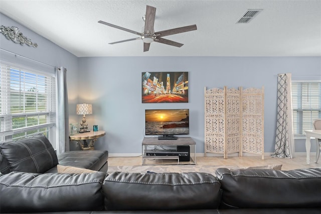 living room featuring a textured ceiling and ceiling fan