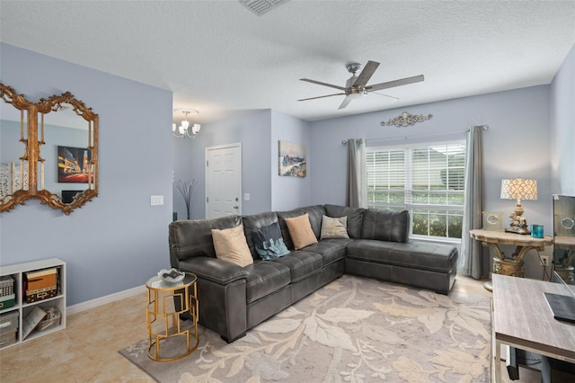 living room with light tile patterned floors, ceiling fan with notable chandelier, and a textured ceiling