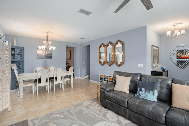 living room featuring a textured ceiling, ceiling fan with notable chandelier, and light tile patterned flooring