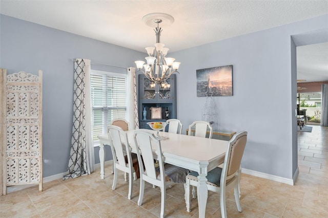 dining space featuring a chandelier and a textured ceiling