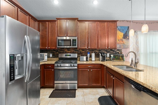 kitchen with light stone countertops, sink, tasteful backsplash, decorative light fixtures, and appliances with stainless steel finishes