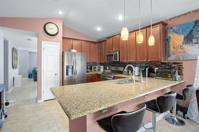 kitchen featuring stainless steel appliances, backsplash, kitchen peninsula, decorative light fixtures, and lofted ceiling