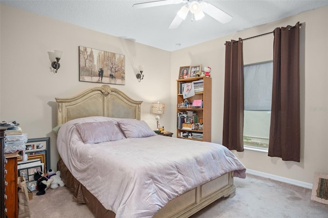 carpeted bedroom featuring ceiling fan and a textured ceiling