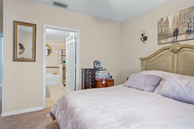 bedroom featuring ensuite bathroom and light colored carpet