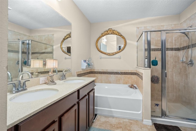 bathroom featuring vanity, tile patterned floors, a textured ceiling, and separate shower and tub