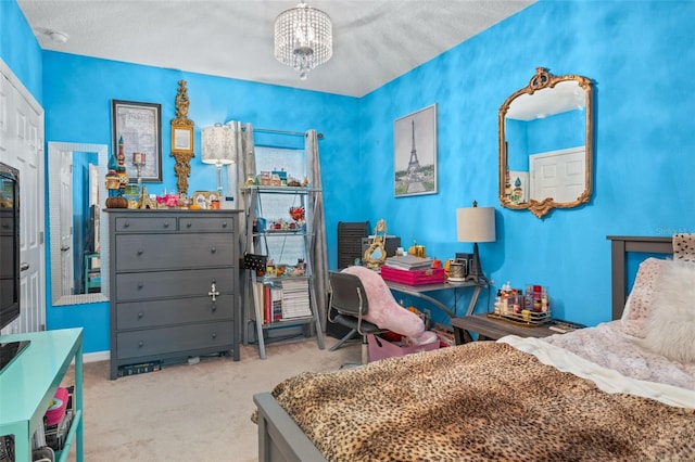 bedroom with a notable chandelier, a textured ceiling, and light carpet