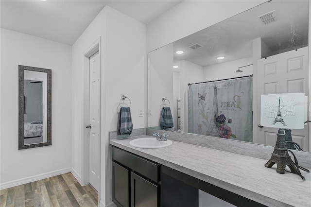 bathroom featuring hardwood / wood-style floors, vanity, and curtained shower