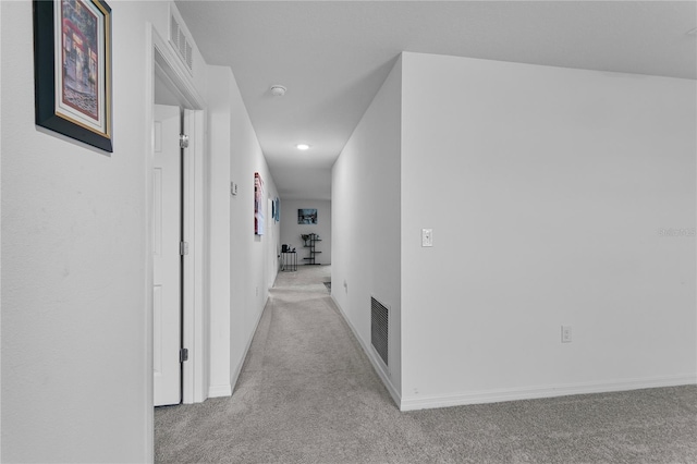 hallway featuring light colored carpet