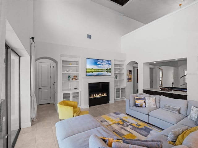 tiled living room with built in shelves and a high ceiling