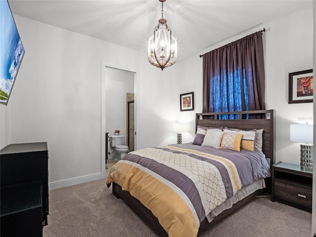 bedroom featuring light colored carpet, a chandelier, and ensuite bath