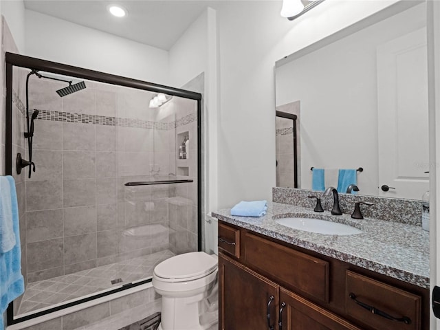 bathroom with vanity, a shower with shower door, and toilet