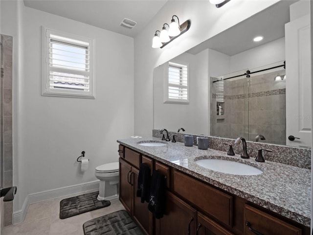 bathroom featuring tile patterned flooring, vanity, toilet, and a shower with shower door