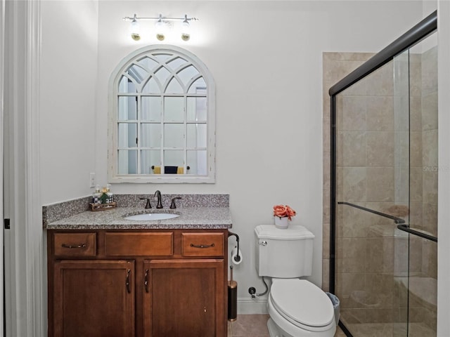 bathroom with walk in shower, vanity, and toilet