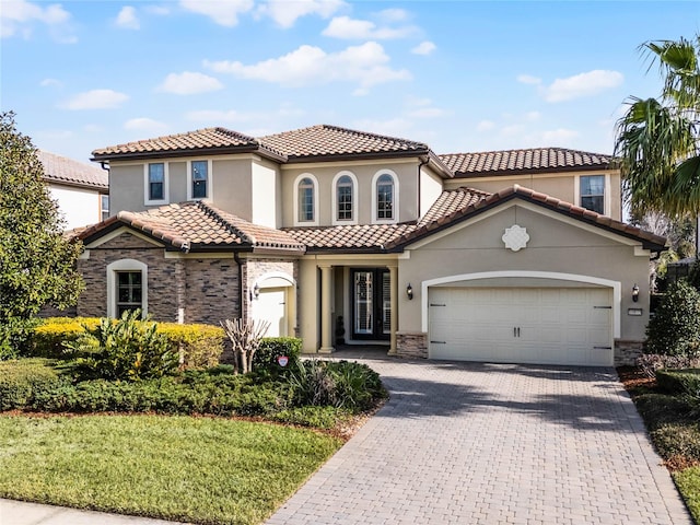 mediterranean / spanish-style house featuring a garage and a front yard