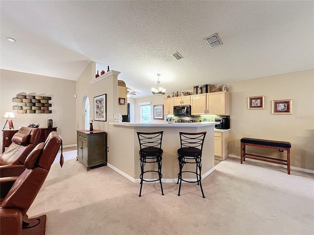 kitchen featuring light colored carpet, pendant lighting, kitchen peninsula, an inviting chandelier, and a breakfast bar area