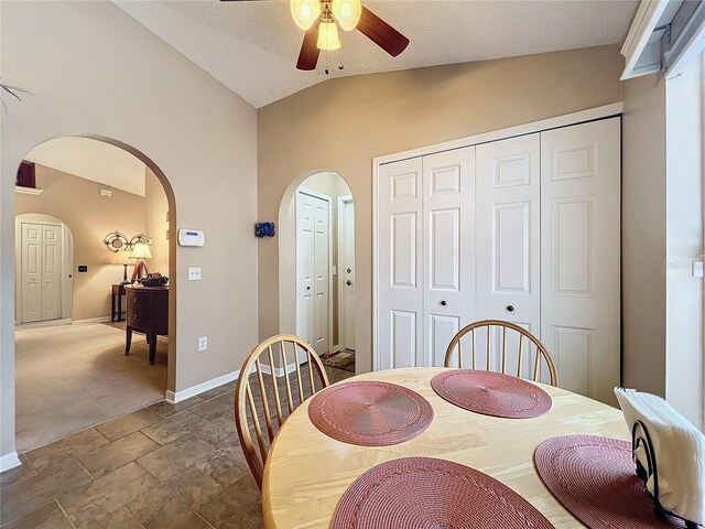 dining room with vaulted ceiling, ceiling fan, and dark carpet