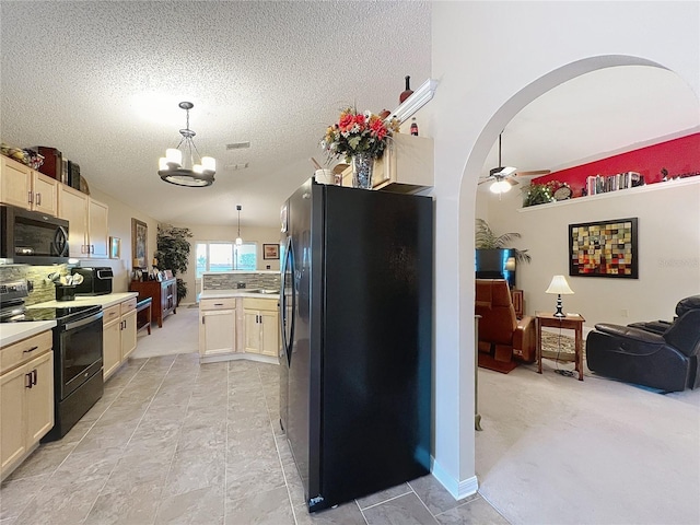 kitchen featuring decorative backsplash, pendant lighting, ceiling fan with notable chandelier, and black appliances