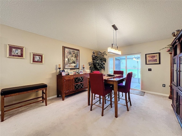 carpeted dining room with a textured ceiling