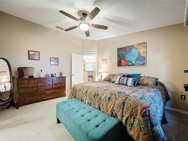 carpeted bedroom with ceiling fan and a textured ceiling