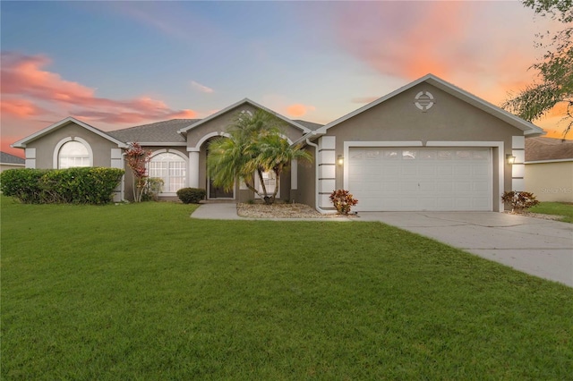 ranch-style home with a garage and a lawn