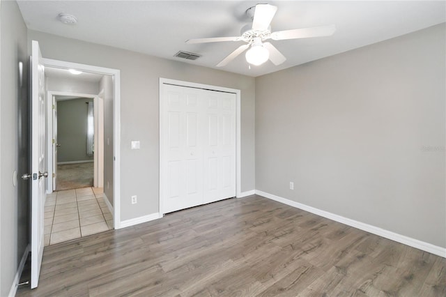 unfurnished bedroom featuring ceiling fan, a closet, and hardwood / wood-style floors