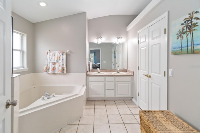 bathroom featuring vanity, tile patterned floors, lofted ceiling, and tiled tub