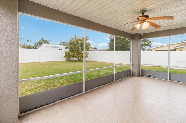 unfurnished sunroom featuring ceiling fan