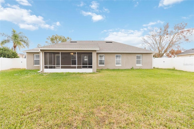 rear view of house with a yard and a sunroom